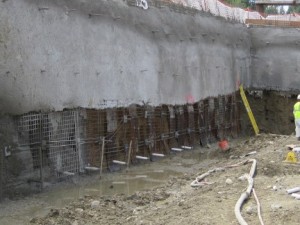 Image of helical tieback anchors with shot crete applied over anchors to stabilize retaining wall